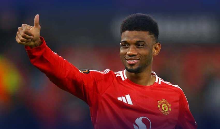 Manchester United’s Amad Diallo celebrates after a match, showing appreciation to fans with a thumbs-up gesture.